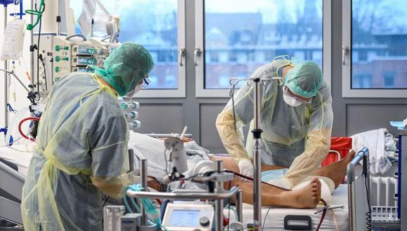 Personal médico asiste a un paciente infectado con el coronavirus en la unidad de cuidados intensivos del hospital universitario Bergmannsheil Klinikum en Bochum, en el oeste de Alemania, el 16 de diciembre de 2021. (INA FASSBENDER / AFP).