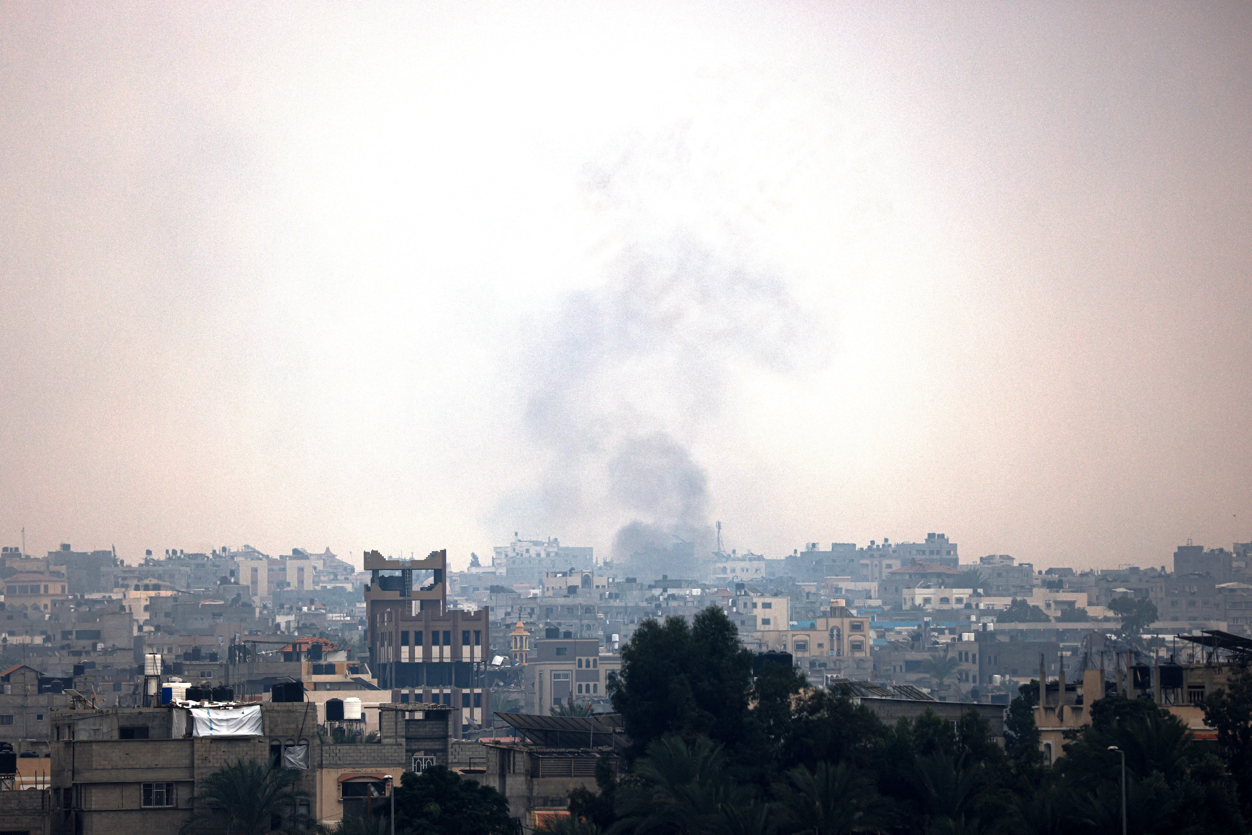 Smoke from Israeli bombings rises over buildings in Khan Younis, in the south of the Gaza Strip.  (Photo by MAHMUD HAMS/AFP).