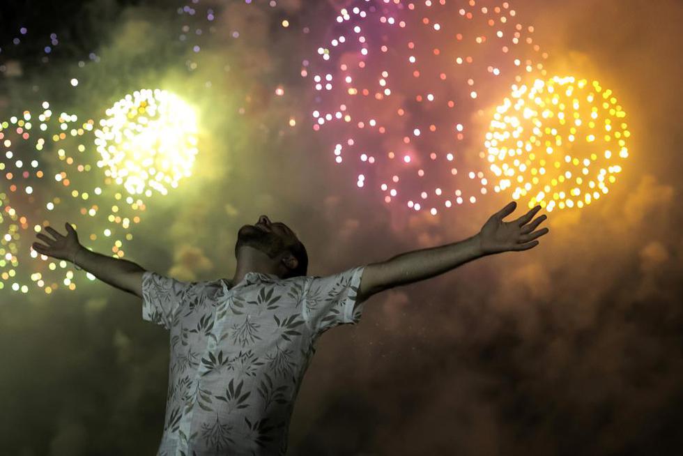 Un hombre celebra el comienzo del Año Nuevo 2022 con el telón de fondo de los fuegos artificiales que explotan en la playa de Copacabana en Río de Janeiro, Brasil, el sábado 1 de enero de 2022. (AP Photo / Bruna Prado).