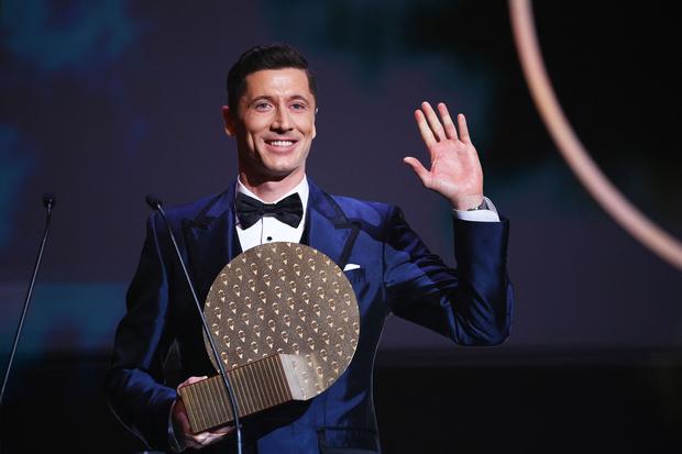 TOPSHOT - Bayern Munich's Polish forward Robert Lewandowski waves on stage after being awarded the Striker of the Year award  the 2021 Ballon d'Or France Football award ceremony at the Theatre du Chatelet in Paris on November 29, 2021. (Photo by FRANCK FIFE / AFP)
