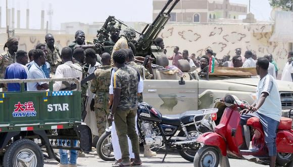 Sudaneses saludan a los soldados del ejército, leales al jefe del ejército Abdel Fattah al-Burhan, en la ciudad de Port Sudan, en el Mar Rojo, el 16 de abril de 2023. (Foto de AFP)