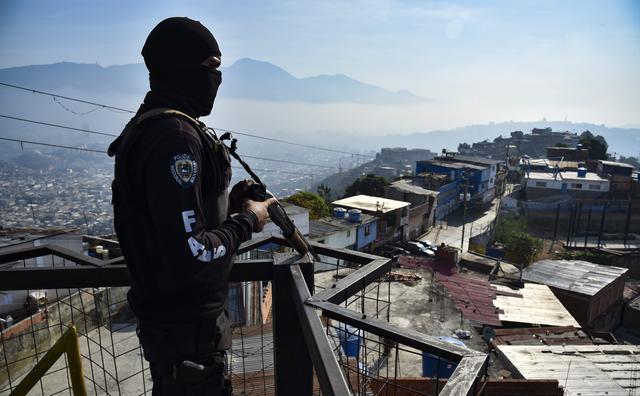 Un miembro del FAES monta guardia en lo alto de un barrio de Caracas, la capital de Venezuela. (AFP).