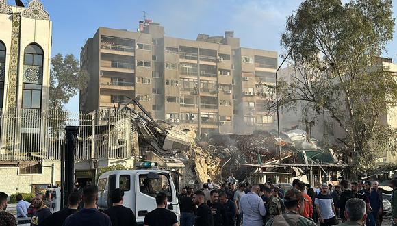 El personal de emergencia y de seguridad se reúne en el lugar de los ataques que alcanzaron un edificio adyacente a la embajada iraní en la capital de Siria, Damasco, el 1 de abril de 2024. (Foto de Maher AL MOUNES / AFP)