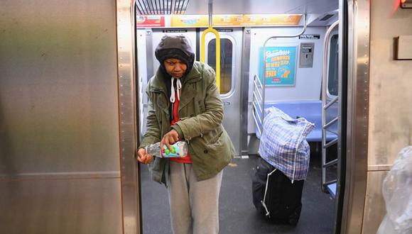 Una mujer sin hogar se lava las manos frente a un tren subterráneo en la ciudad de Nueva York. Ellos han ocupado los vagones del metro durante la pandemia del coronavirus. (Foto: AFP/Angela Weiss)
