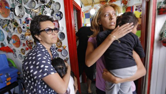 Los israelíes se refugian en una tienda cuando suenan las sirenas durante un ataque con cohetes desde la Franja de Gaza hacia Israel, el 13 de mayo de 2021. (Foto de Gil COHEN-MAGEN / AFP).