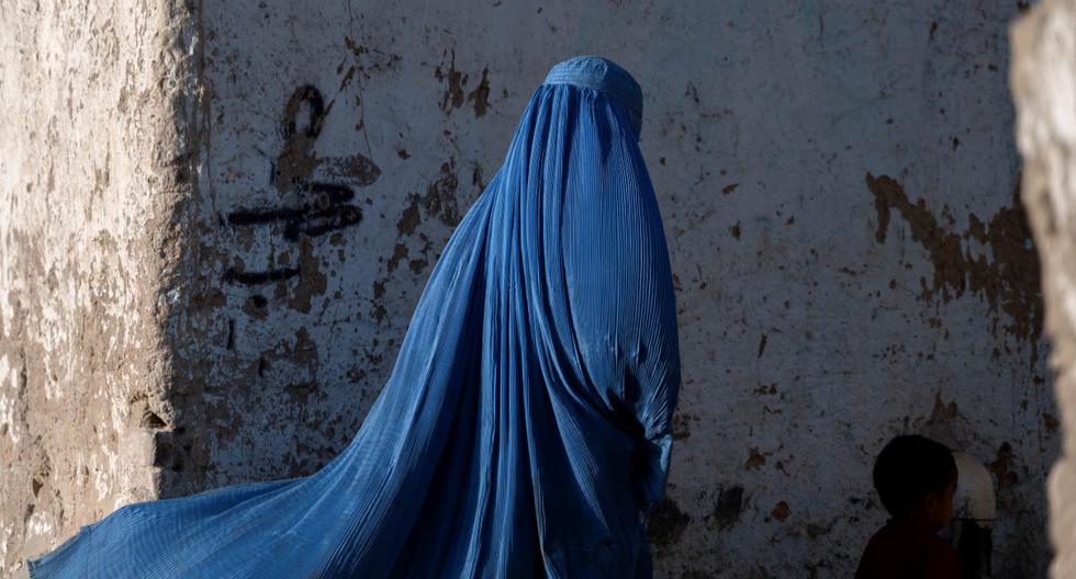 Una mujer afgana vestida con burka camina con un niño en Kabul, Afganistán, el 28 de abril de 2022. (Wakil KOHSAR / AFP).