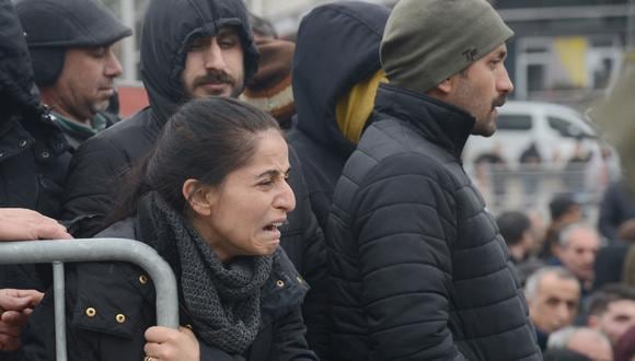 Una mujer reacciona mientras la gente observa al personal de rescate buscar víctimas y sobrevivientes entre los escombros de los edificios en Diyarbakir, el día después de que un terremoto de magnitud 7,8 azotara el sureste del país, el 7 de febrero de 2023. (Foto: ILYAS AKENGIN / AFP)