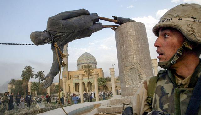FILE PHOTO: A U.S. soldier watches as a statue of Iraq's President Saddam Hussein falls in central Baghdad, Iraq April 9, 2003. REUTERS/Goran Tomasevic/File Photo