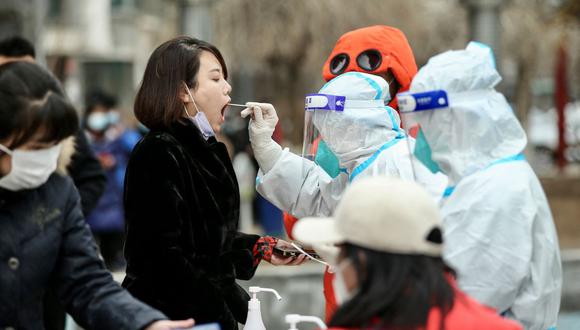 Esta foto tomada el 14 de marzo de 2022 muestra a una residente que se somete a una prueba de coronavirus covid-19 en Shenyang, en la provincia nororiental china de Liaoning. (AFP).