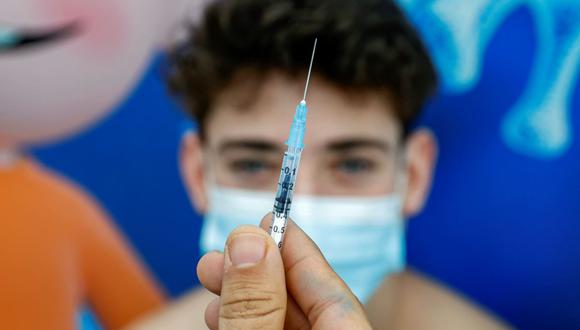 Michael, un adolescente de 16 años, recibe una dosis de la vacuna contra el coronavirus COVID-19 de Pfizer-BioNtech, en Tel Aviv, Israel, el 23 de enero de 2021. (JACK GUEZ / AFP).