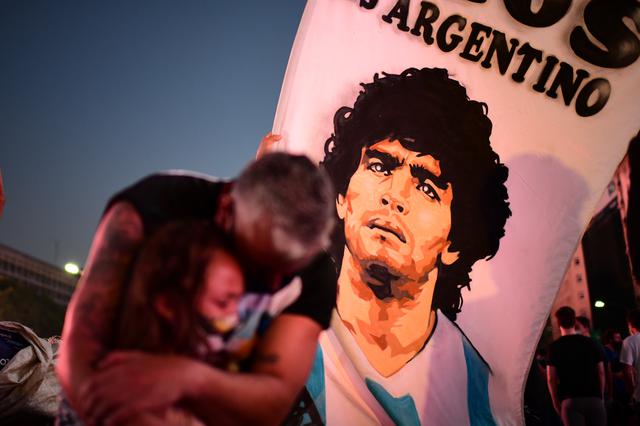 Un padre y su hija, fanáticos de la leyenda del fútbol argentino Diego Maradona, lloran mientras se reúnen junto al Obelisco para rendir homenaje el día de su muerte en Buenos Aires. El cuerpo permanecerá en el palacio presidencial durante tres días de duelo nacional, anunció la presidencia. (Foto: Ronaldo Schemidt / AFP)