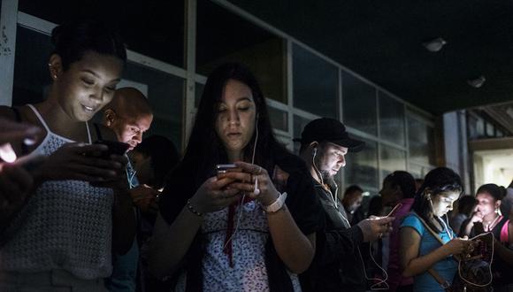 People use mobile devices at a wireless communications (Wifi) hotspot at night in Havana, Cuba, on Saturday, Jan. 27, 2018. The Information Technology Industry Council (ITI), which represents companies including Alphabet Inc.'s Google, Microsoft Corp., and Facebook Inc., said it will come together with six other governmental and civil liberties organizations as part of the U.S. State Department's newly formed Cuba Internet Task Forceóan initiative that has drawn ire from the Cuban government. Photographer: Francesco Pistilli/Bloomberg