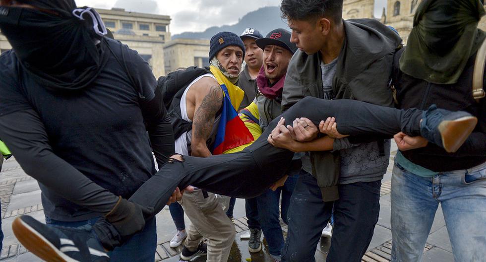 Manifestante herido es llevado por sus compañeros durante enfrentamientos por la huelga nacional para protestar contra el gobierno del presidente colombiano Ivan Duque, en Bogotá. (Foto: AFP)