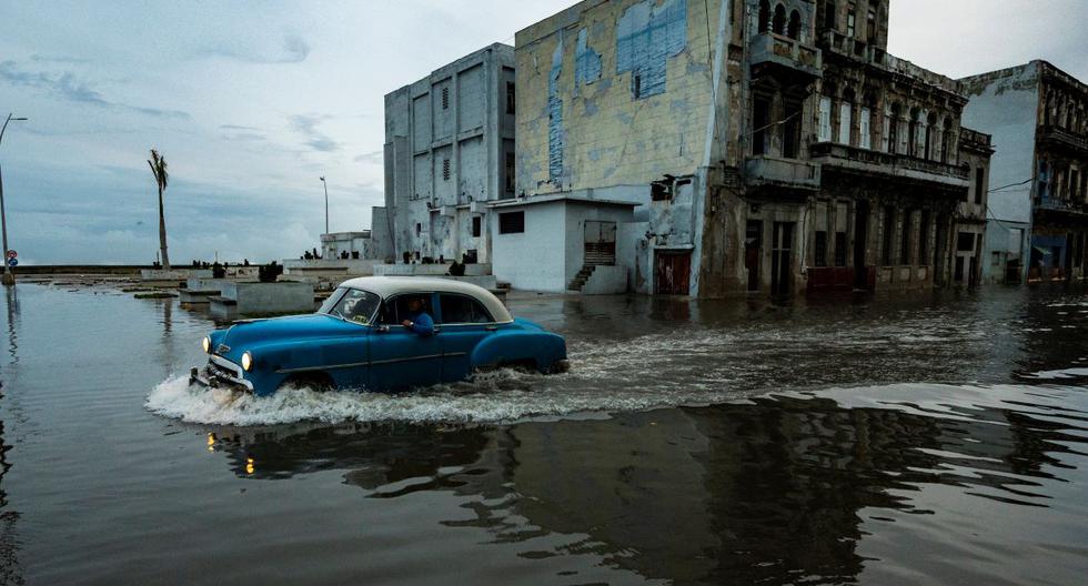Un viejo automóvil estadounidense transita por una calle inundada de La Habana, Cuba, el 28 de septiembre de 2022, tras el paso del huracán Ian. (YAMIL LAGE / AFP).
