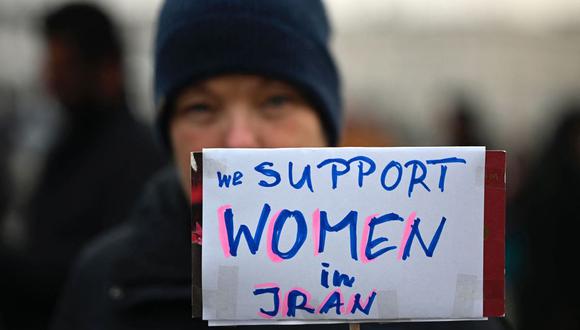 Una manifestante sostiene un cartel que dice "Apoyamos a las mujeres en Irán" durante una marcha de mujeres en solidaridad con las manifestantes en Irán en Berlín, el 10 de diciembre de 2022. (Foto de Tobias Schwarz / AFP)