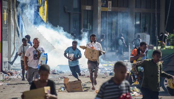Los saqueadores y oportunistas aprovecharon la escasa situación de seguridad para desatar el caos durante las protestas en la ciudad de Port Mores en Papúa Nueva Guinea que empezaron ayer, miércoles 10 de enero. (Photo by Andrew KUTAN / AFP)