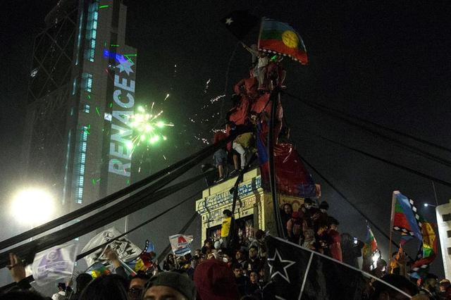 Miles de personas celebran en la Plaza Italia el triunfo del Apruebo en el histórico plebiscito en Chile. (EFE/ Alberto Valdes).