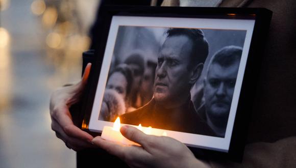 Un manifestante sostiene velas y una fotografía del fallecido líder de la oposición Alexei Navalny. (Foto de Ludovic MARIN / AFP)