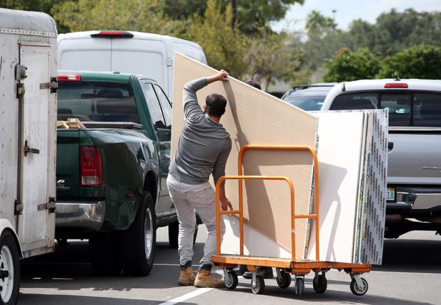 Local residents load construction materials to protect their homes in Kissimmee, Florida on September 26, 2022.  (Greg Newton/AFP)