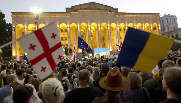 Los manifestantes sostienen banderas nacionales de Georgia, la Unión Europea y Ucrania durante una manifestación pública frente al edificio del Parlamento en Tbilisi, Georgia, para mostrar su apoyo a la candidatura del país a la Unión Europea.
