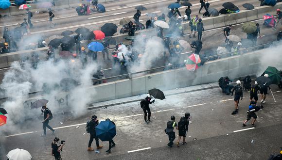 Los manifestantes reaccionan después de que la policía disparó lágrimas cerca de la sede del gobierno de Hong Kong el 31 de agosto de 2019. (Foto: AFP)
