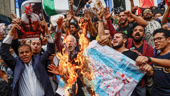 Los egipcios queman banderas israelíes mientras participan en una manifestación frente al Sindicato de Periodistas en el centro de El Cairo el 18 de octubre de 2023, en protesta por un ataque a un hospital de Gaza que mató a cientos de personas el día anterior. (Foto de Khaled DESOUKI / AFP)