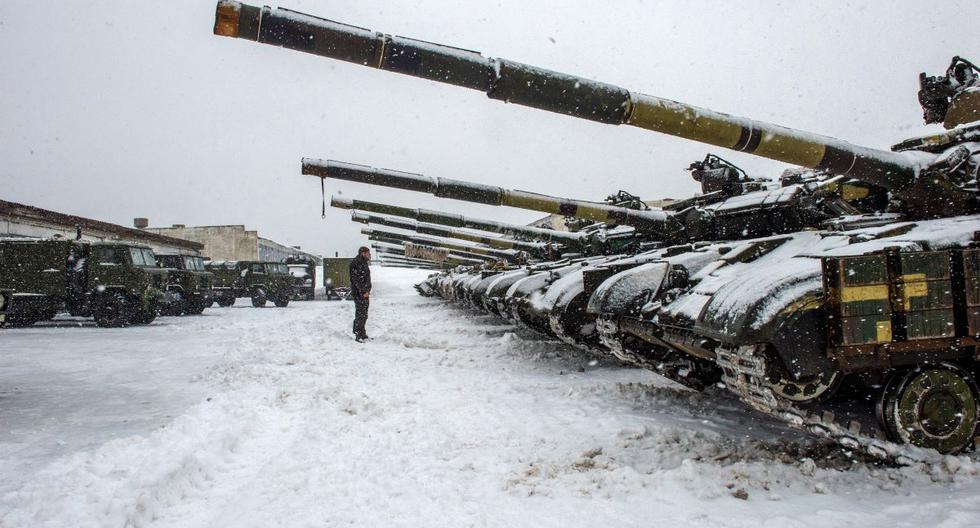Un integrante de las Fuerzas Militares de Ucrania se para frente a los tanques de la 92ª brigada mecanizada estacionados en su base cerca de la aldea de Klugino-Bashkirivka, en la región de Kharkiv, el 31 de enero de 2022. (Serguéi BOBOK / AFP).