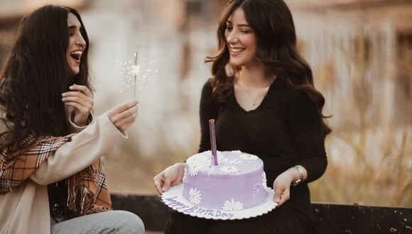 Esta es una imagen referencial de una mujer a punto de darle un pastel de cumpleaños a otra. (Foto: Reem Mansour / Pexels)