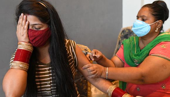 Una trabajadora de la salud vacuna a una mujer con la vacuna Covishield contra el coronavirus Covid-19 en Amritsar, India, el 20 de junio de 2021. (Foto de Narinder NANU / AFP).