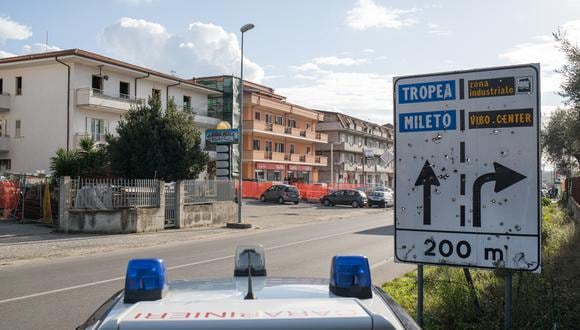 Un automóvil de la policía de Carabinieri patrulla junto a una señal de tráfico llena de balas durante una actividad de control de carreteras, el 18 de noviembre de 2021 en Vibo Valentia, Calabria. (Foto referencial de Gianluca CHININEA / AFP)