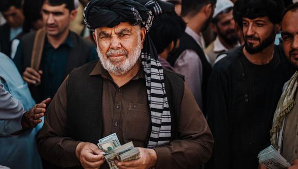 Un cambista ofrece dólares en un mercado de Kabul, la capital de Afganistán. (GETTY IMAGES).
