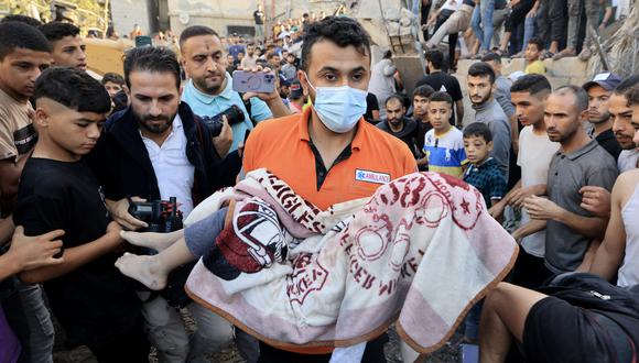 Un palestino lleva el cuerpo cubierto de un niño muerto en el bombardeo israelí de Khan Yunis en el sur de la Franja de Gaza el 4 de noviembre de 2023, en medio de las batallas en curso entre Israel y el grupo palestino Hamás. (Foto de Mahmud HAMS / AFP)