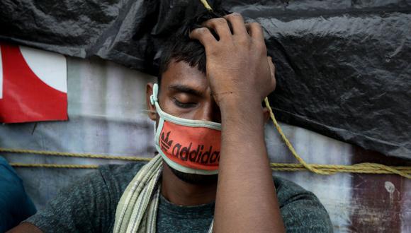 Un trabajador indio descansa mientras espera un tren local en una estación en Kolkata, India oriental, el 4 de mayo de 2021. (EFE/EPA/PIYAL ADHIKARY).