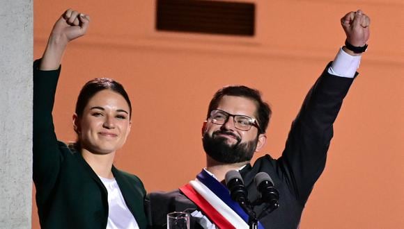 El presidente de Chile, Gabriel Boric, y su novia, Irina Karamanos, saludan a sus seguidores después de un discurso en el Palacio de La Moneda en Santiago. (MARTIN BERNETTI / AFP)