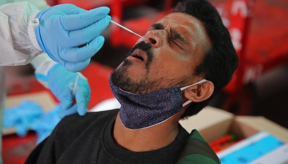 Un trabajador de la salud toma una muestra nasal de un hombre para una prueba de coronavirus en la estación de tren de Bangalore, India, el 29 de noviembre de 2021. (EFE / EPA / JAGADEESH NV).
