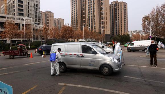 Un trabajador rocía desinfectante en una camioneta afuera de un mercado en Xi'an, en la provincia norteña china de Shaanxi, en plena pandemia de coronavirus. (STR / AFP).