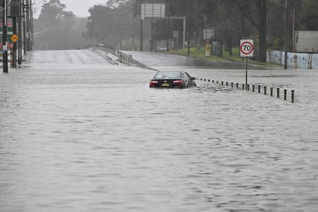 An abandoned car is seen in floodwaters on Newbridge Road in Chipping Norton in western Sydney, Australia