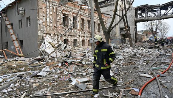 Un rescatista pasa frente a edificios destruidos tras un bombardeo en la región de Kharkiv, Ucrania, el 16 de abril de 2022. (SERGEY BOBOK / AFP).