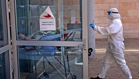 Personal médico del Magen David Adom transfiere a un paciente de coronavirus al Hospital Hadassah Ein Kerem en Jerusalén, Israel, el 15 de agosto de 2021. (Menahem KAHANA / AFP).