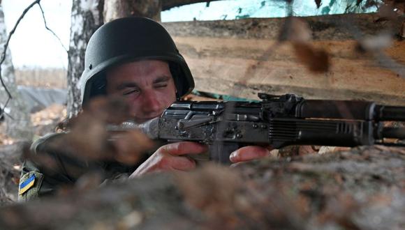Un soldado de la Guardia Nacional de Ucrania toma posición en una trinchera en los territorios liberados del norte de la región de Kharkiv el 21 de octubre de 2022, en medio de la invasión militar rusa de Ucrania. (Foto de SERGEY BOBOK / AFP)