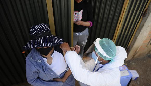 Una mujer es inoculada contra COVID-19 por personal del Ministerio de Salud de Bolivia. (Foto: Jorge Bernal / AFP)