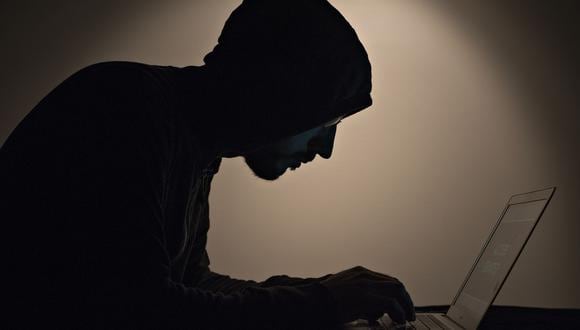 Imagen referencial de un hombre trabajando en su computadora y emulando el estereotipo de un hacker. (Foto: Bloomberg).