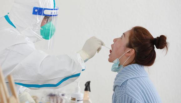 Una mujer se somete a una prueba de ácido nucleico para el coronavirus Covid-19 en Hangzhou, en la provincia oriental china de Zhejiang, el 11 de marzo de 2022. (AFP).