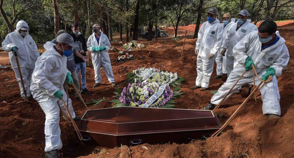 Los empleados son vistos enterrando el ataúd de una persona en el cementerio de Vila Formosa, en las afueras de Sao Paulo. Brasil es uno de los países más golpeados por el coronavirus. (AFP / NELSON ALMEIDA).