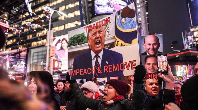 Miles de personas acudieron este martes a la céntrica plaza neoyorquina de Times Square para pedir que salga adelante el juicio político contra Donald Trump. (Foto: AFP).