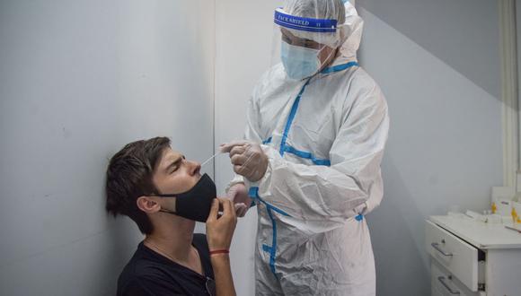 Un trabajador de la salud toma muestras de un hombre para detectar el coronavirus COVID-19 en Mar del Plata, Argentina, el 11 de enero de 2022. (Mara Sosti / AFP).