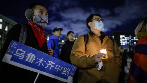 Un hombre sostiene una vela mientras la gente se reúne en la Universidad de Columbia durante una protesta en apoyo de las manifestaciones celebradas en China para pedir el fin de los bloqueos por covid-19, en Nueva York el 28 de noviembre de 2022. (Foto de KENA BETANCUR / AFP)