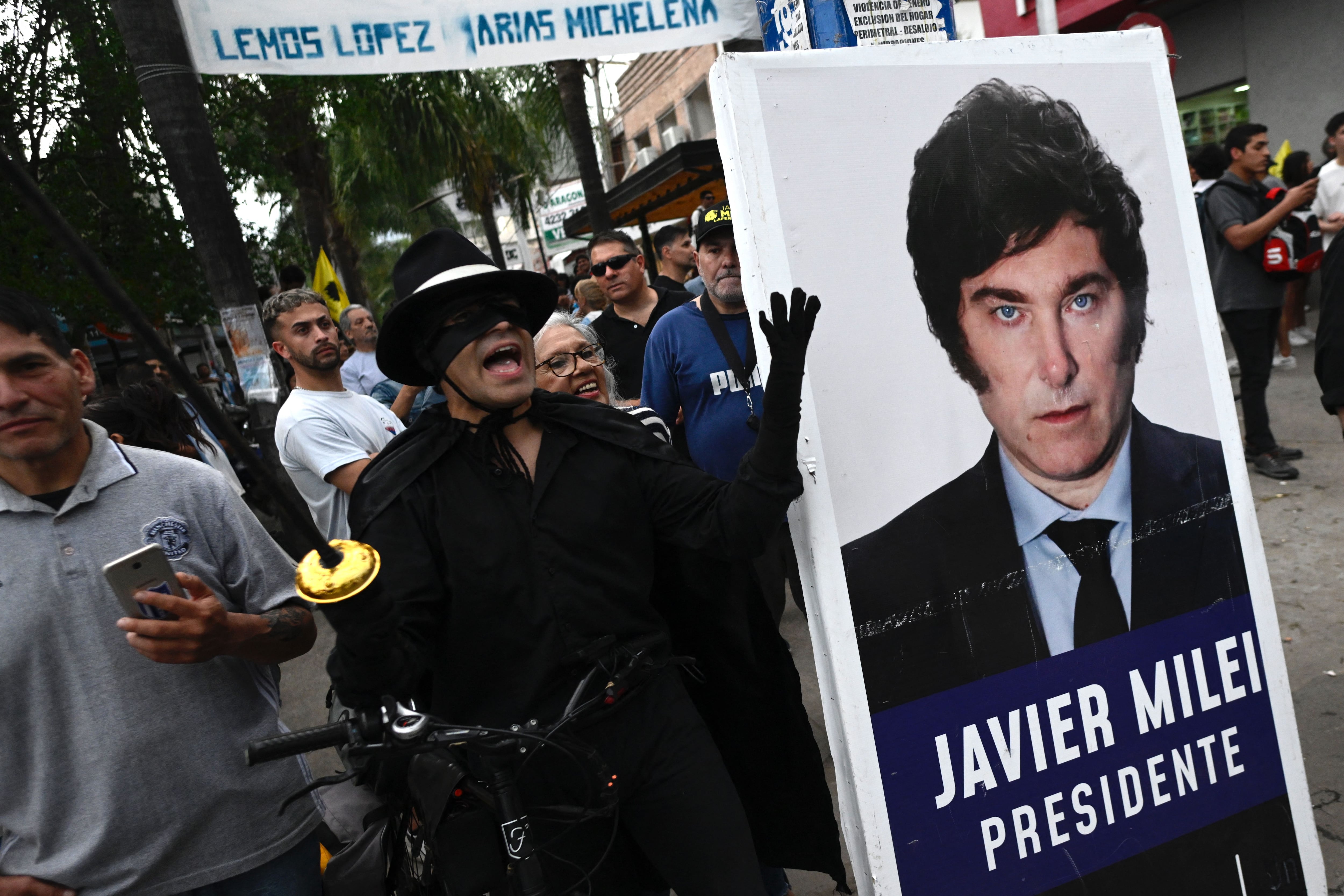 A supporter of Javier Milei dressed as the television character Zorro shouts slogans during a campaign rally in Ezeiza, Buenos Aires province, on November 15, 2023. (Photo by Luis ROBAYO/AFP).