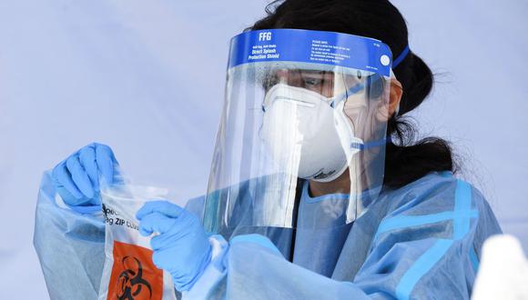 Una trabajadora de la salud coloca un vial de prueba de PCR Covid-19 en una bolsa en California, Estados Unidos, el 18 de enero de 2022, en plena pandemia de coronavirus. (Patrick T. FALLON / AFP).