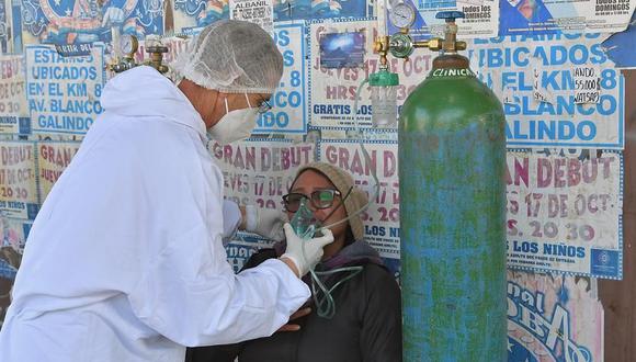Un integrante del personal sanitario atiende a una persona que acude a realizarse la prueba de detección de coronavirus COVID-19 en un puesto de atención médica instalado en plena calle en Cochabamba, Bolivia. (EFE/Jorge Ábrego).